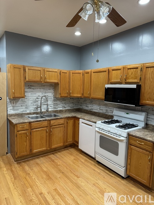 A kitchen with wooden cabinets and a white stove top oven.