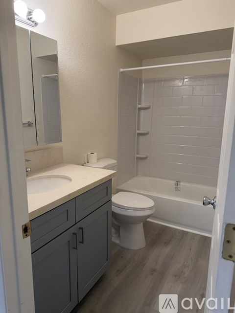 A bathroom with a toilet, sink, and bathtub.