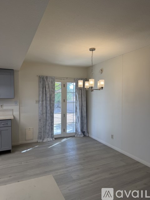 A well-lit room with a grey cabinet and a window with curtains.