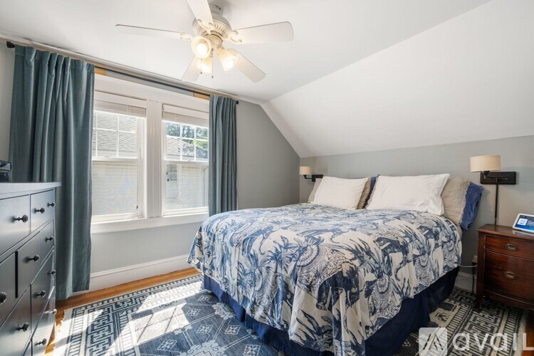 A bedroom with a bed, dresser, and window.
