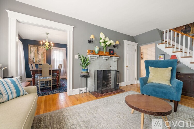 A living room with a blue chair and a fireplace.