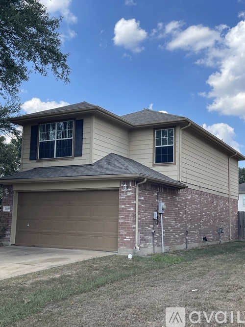 A house with a garage door and a brick wall.