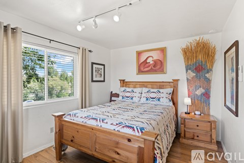 A bedroom with a large bed, wooden furniture, and a window with curtains.