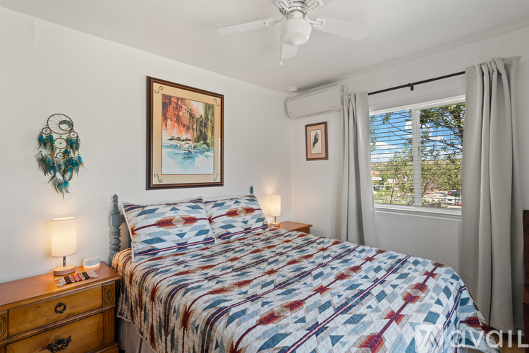 A bedroom with a large bed and a painting on the wall.