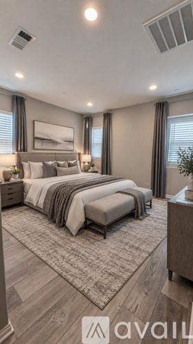 A bedroom with a large bed and a painting on the wall.