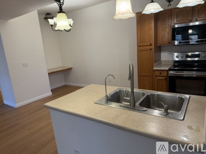A kitchen with a sink and a stove top oven.