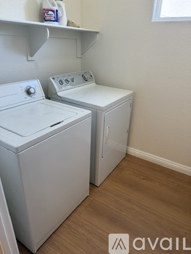A white washing machine and dryer in a small laundry room.