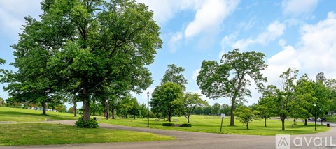 A park with a grassy area and trees.