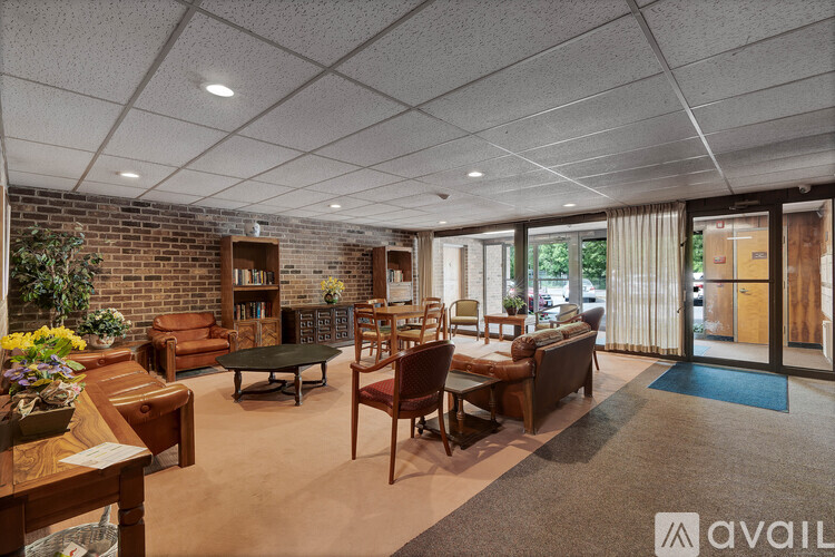 A living room with a brick wall and a variety of furniture.