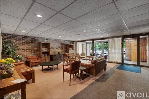 A living room with a brick wall and a variety of furniture.