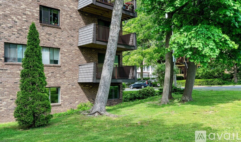 A building with a balcony and trees in front.
