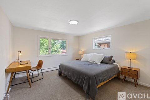 A bedroom with a bed, desk, and chair.