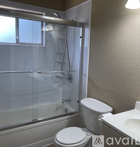 A bathroom with a toilet, sink, and shower.