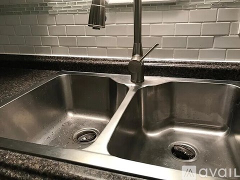 A white bathtub with a shower head and faucet.
