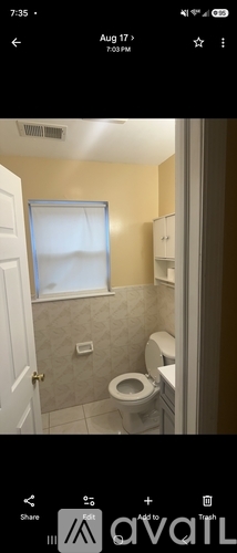 A bathroom with a toilet and a window.