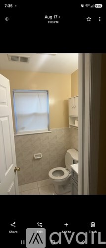 A bathroom with a toilet and a window.