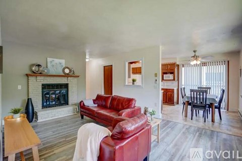 A living room with a red couch and a fireplace.