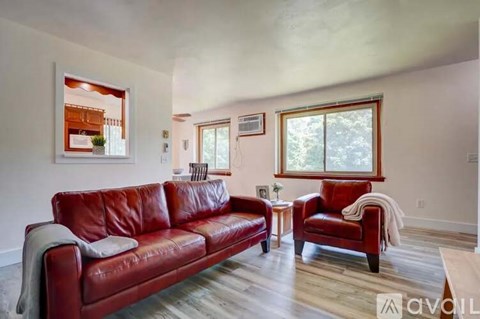 A living room with a red couch and a red chair.