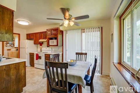 A kitchen with a table and chairs in front of a window.