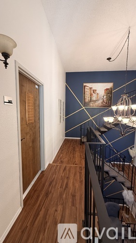 A hallway with a wooden floor and a metal staircase.