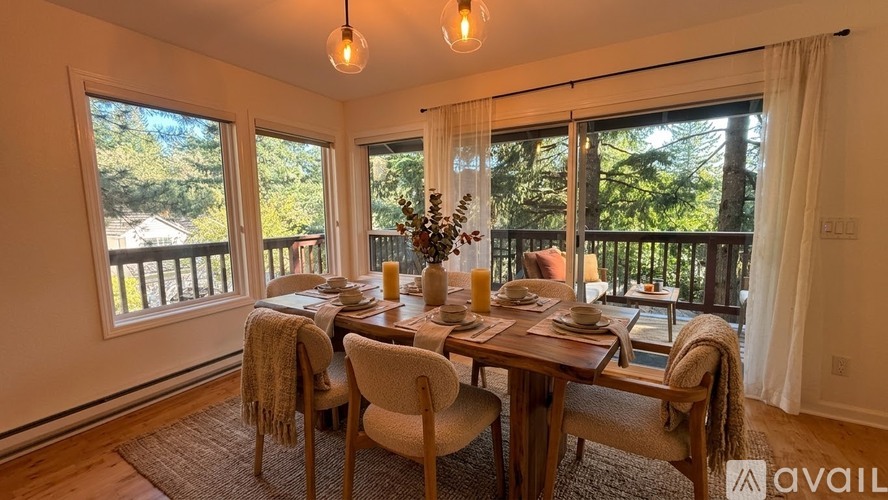 A dining room with a table set for four and a view of the backyard.