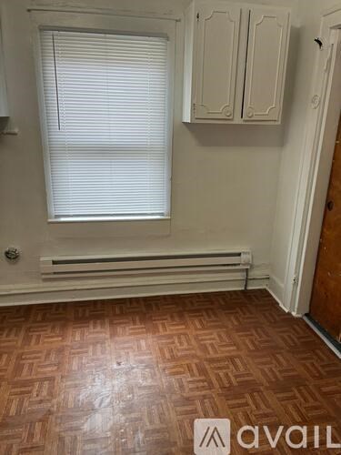 A room with a wooden floor and white walls.