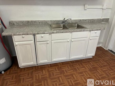 A kitchen with white cabinets and a granite countertop.