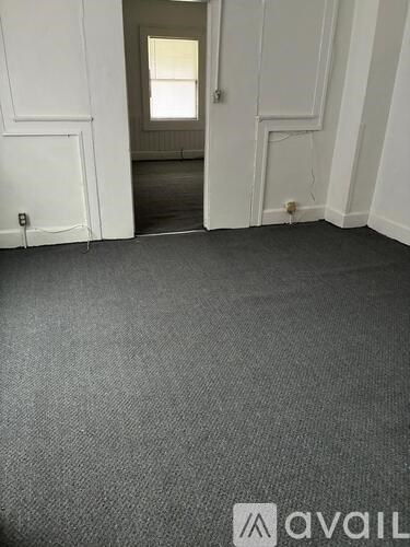 A room with a carpeted floor and white walls.
