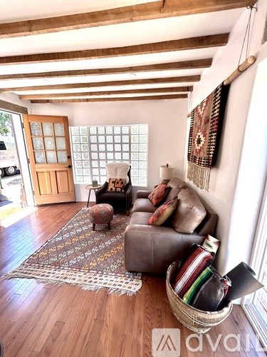 A living room with a brown leather couch and a woven basket on the floor.