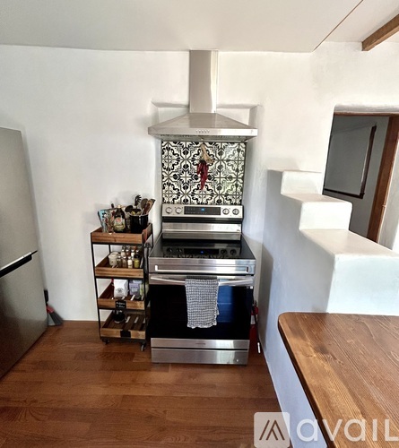 A modern kitchen with a stove top oven and a refrigerator.
