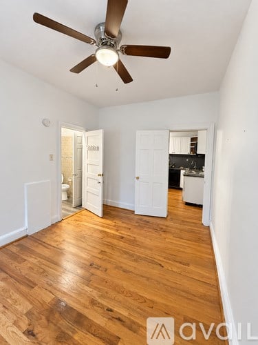 A room with a ceiling fan and wooden floors.