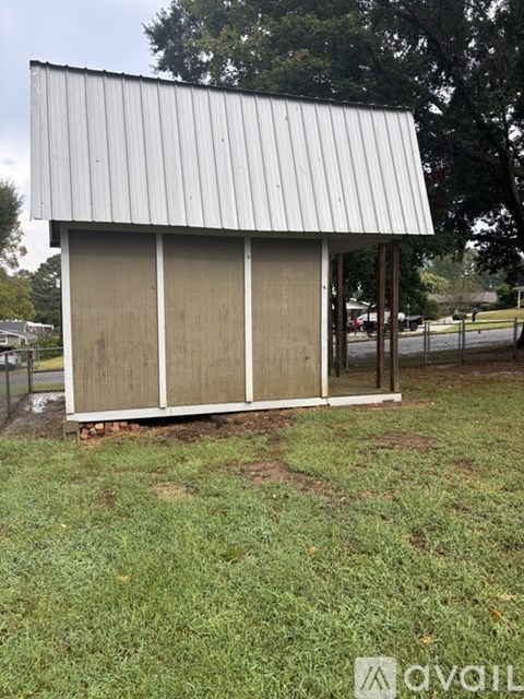A small building with a metal roof and wooden doors.