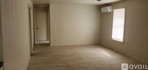 A room with a tiled floor and a window on the right side.
