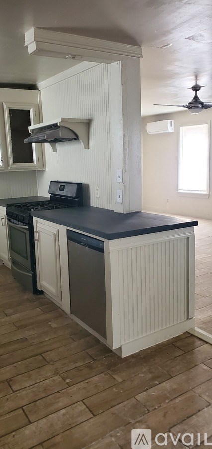 A kitchen with a black countertop and white cabinets.