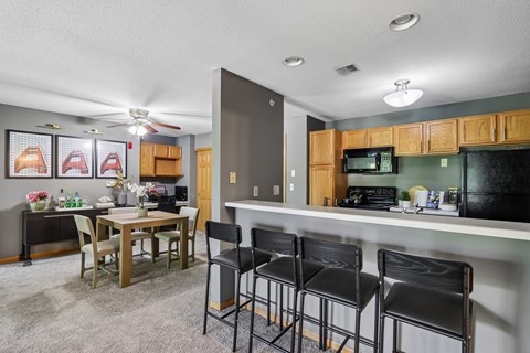 A kitchen area with a table and chairs.