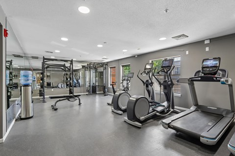 A spacious gym with treadmills, elliptical machines, and other exercise equipment.