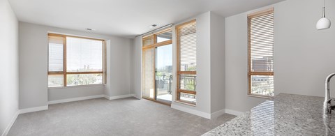A spacious, empty room with a large window and sliding glass doors.