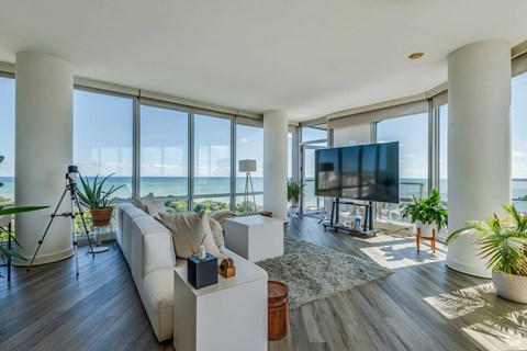 A modern living room with a large white couch and a flat screen TV.