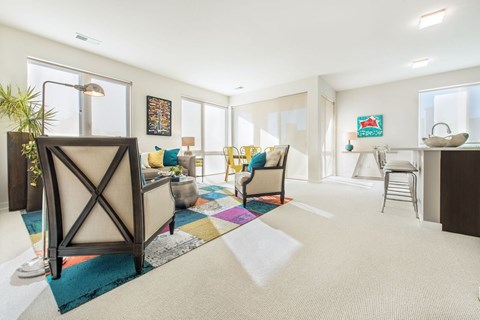 A living room with a couch, chairs, and a rug.
