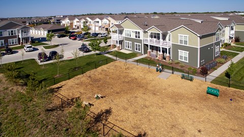 A large grassy field in front of apartment buildings.