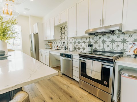 A kitchen with a white counter top and stainless steel appliances.
