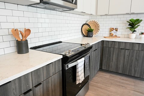 A modern kitchen with a black oven and wooden cabinets.