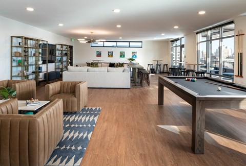 A room with a pool table and a bar area.