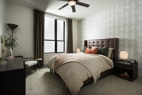 A bedroom with a large bed and a ceiling fan.
