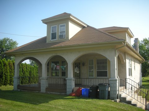 A house with a brown roof and a white wall with a brown trim.