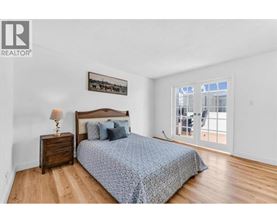 A bedroom with a bed, nightstand, and a picture on the wall.