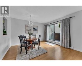 A dining room with a table set for two and a chandelier.