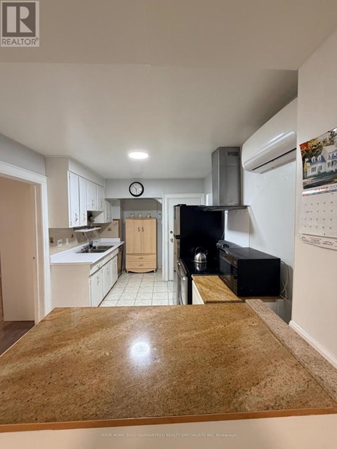 A kitchen with a wooden counter top and white cabinets.