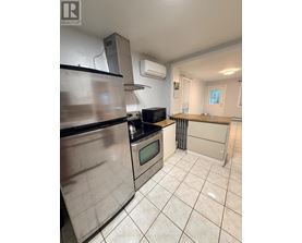 A kitchen with a stainless steel refrigerator, microwave, and oven.