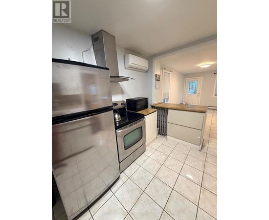 A kitchen with a stainless steel refrigerator, microwave, and oven.
